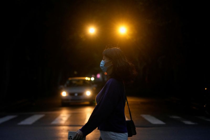 &copy; Reuters. امرأة تضع كمامة للوقاية من فيروس كورونا في شنغهاي يوم الخميس. تصوير: آلي سونج - رويترز.