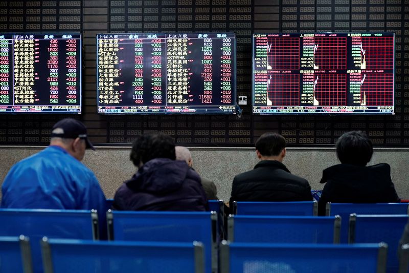 &copy; Reuters. FILE PHOTO: Investors look at screens showing stock information at a brokerage house in Shanghai, China January 16, 2020. REUTERS/Aly Song
