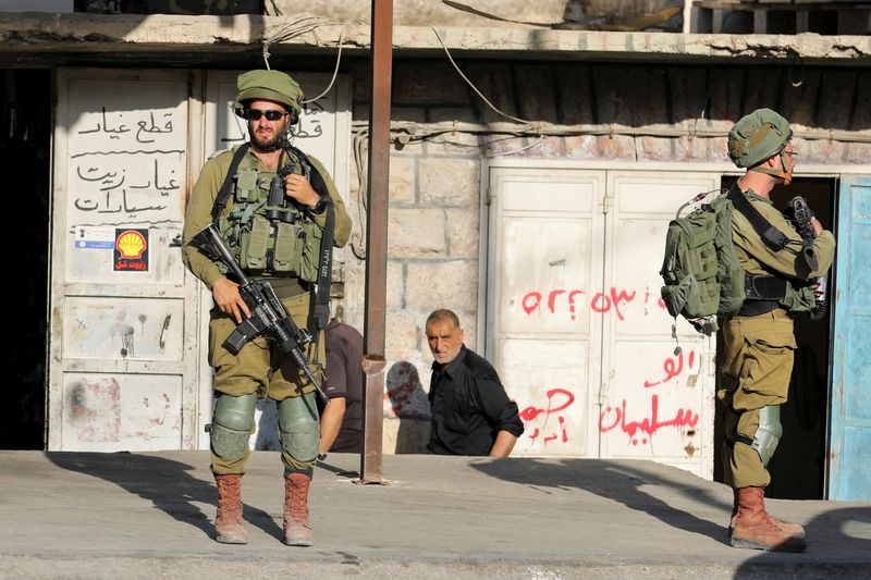 &copy; Reuters. Israeli soldiers stand while stationed outside a Palestinian shop in Huwara, Israeli-occupied West Bank, May 26, 2022. REUTERS/Raneen Sawafta