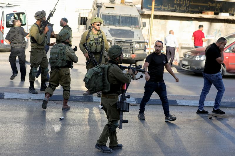 &copy; Reuters. فلسطينيون يواجهون جنودا إسرائيليون داهموا بلدة حوارة بوسط الضفة الغربية بالقرب من مدينة نابلس يوم الخميس. تصوير: رنين صوافطة - رويترز.
