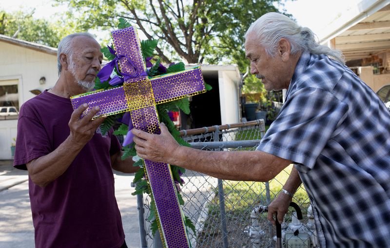 &copy; Reuters. Retired pastor Julian Moreno, receives condolences and a cross from his neighbour, Rene Bradyhill, after his granddaughter, Lexi Rubio, was killed on May 24 during a mass shooting at Robb Elementary School, in Uvalde, Texas, U.S., May 26, 2022. REUTERS/Nu