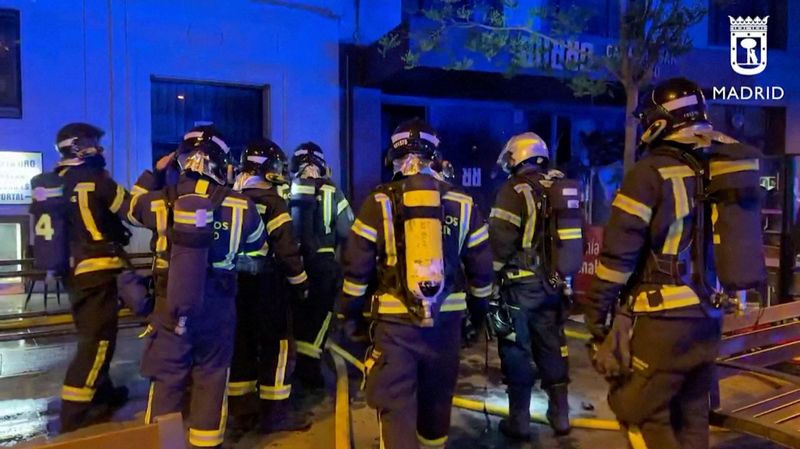 &copy; Reuters. رجال إطفاء يتجمعون خارج مطعم اشتعلت فيه النيران في مدريد يوم السبت. صورة لرويترز من خدمة الطوارئ في مدريد.