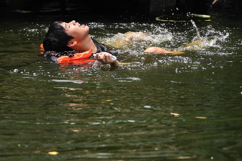 &copy; Reuters. رجل يستحم في إحدى القنوات المائية مع تجاوز درجات الحرارة 45 درجة مئوية في بانكوك يوم السبت. تصوير: تشاليني تيراسوبا - رويترز