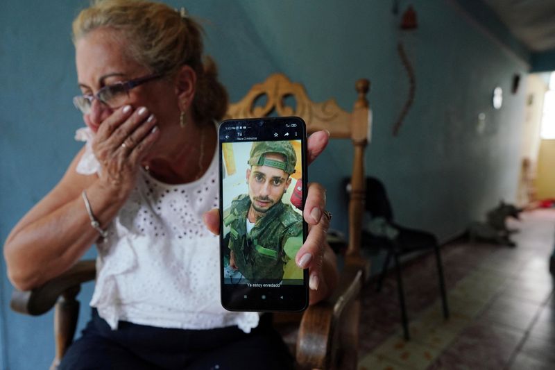 © Reuters. Marilin Vinent muestra una foto de su hijo Dannys Castillo vestido con uniforme militar en un mensaje del 22 de agosto de su hijo que dice en español 
