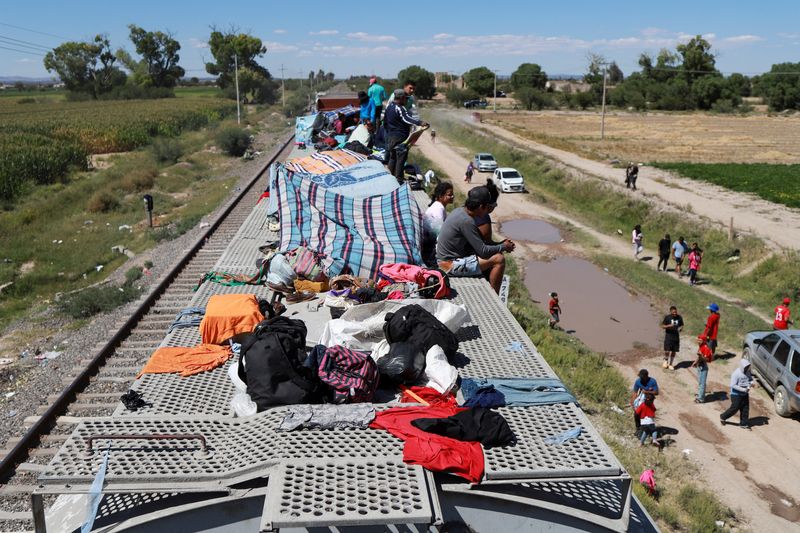 © Reuters. Migrants stranded while traveling by train towards the U.S. border sit on railroad cars, amid the ongoing suspension of dozens of northbound trains over fears around migrant safety, in the community of Miguel Hidalgo de Ojuelos, on the outskirts of Fresnillo, in Zacatecas state, Mexico September 29, 2023. REUTERS/Edgar Chavez