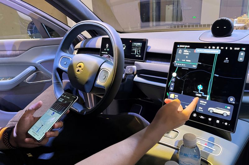 &copy; Reuters. موظف يشرح لممثلي وسائل الإعلام طريقة اتصال نيو فون بسيارة خلال يوم التكنولوجيا الخاص بصانع السيارات الكهربائية الصينية في شنغهاي بالصين يو