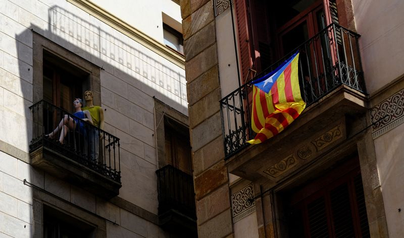 © Reuters. FILE PHOTO: Mannequins are pictured on a balcony near an Estelada (Catalan separatist flag), hanging on a balcony in downtown Barcelona, Spain September 23, 2023. REUTERS/Nacho Doce/File photo