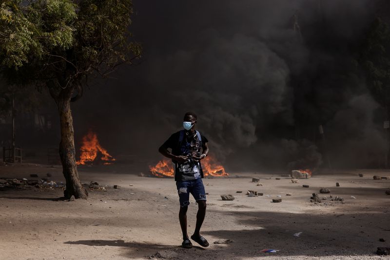 &copy; Reuters. Un manifestant sénégalais observe les affrontements avec la police anti-émeute alors qu'ils protestent contre le report de l'élection présidentielle du 25 février, à Dakar, au Sénégal. /Photo prise le 9 février 2024/REUTERS/Zohra Bensemra