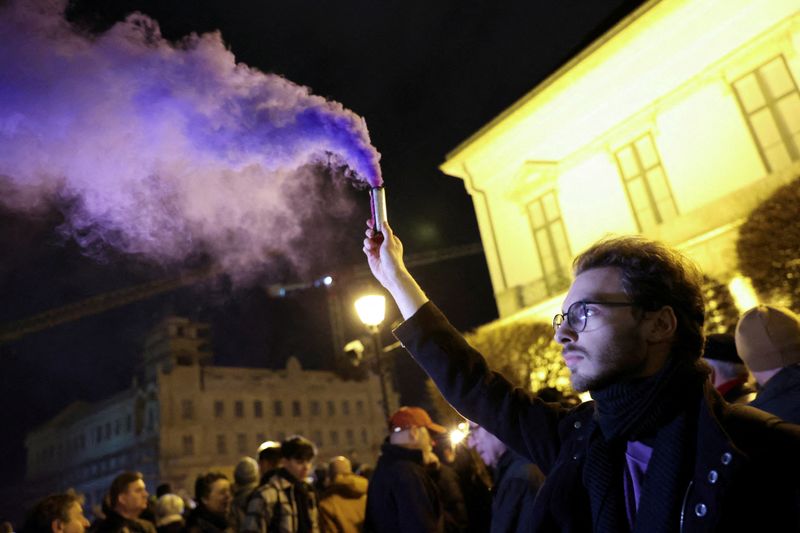 © Reuters. FILE PHOTO: A man uses a smoke flare during a protest to demand the resignation of Hungarian President Katalin Novak, after she granted pardon in a sex abuse case, near Sandor Palace, in Budapest, Hungary, February 9, 2024. REUTERS/Bernadett Szabo/File Photo