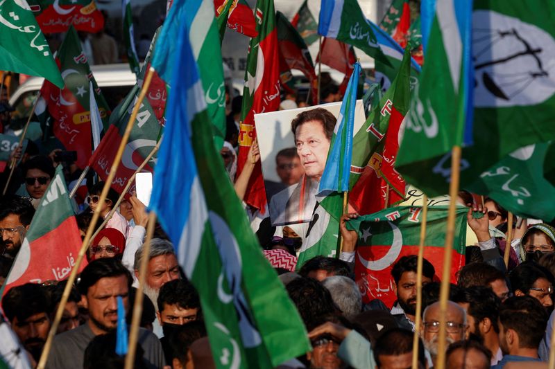 © Reuters. A portrait of the former Prime Minister Imran Khan is seen amid flags of Pakistan Tehreek-e-Insaf (PTI) and the religious and political party Jamat-e-Islami (JI) as supporters attend a joint protest demanding free and fair results of the elections, outside the provincial election commission of Pakistan (ECP)in Karachi, Pakistan February 10, 2024. REUTERS/Akhtar Soomro