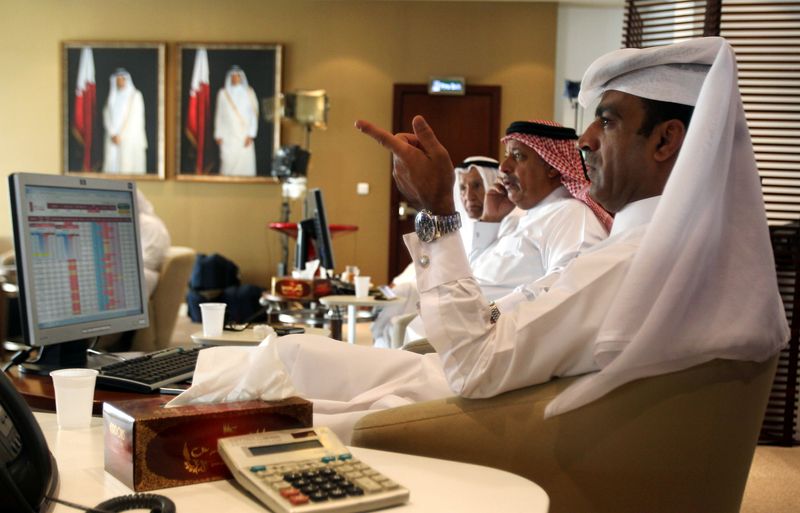 &copy; Reuters. مستثمرون يراقبون شاشات تعرض تعرض معلومات الأسهم في بورصة قطر بالدوحة في صورة من أرشيف رويترز.
