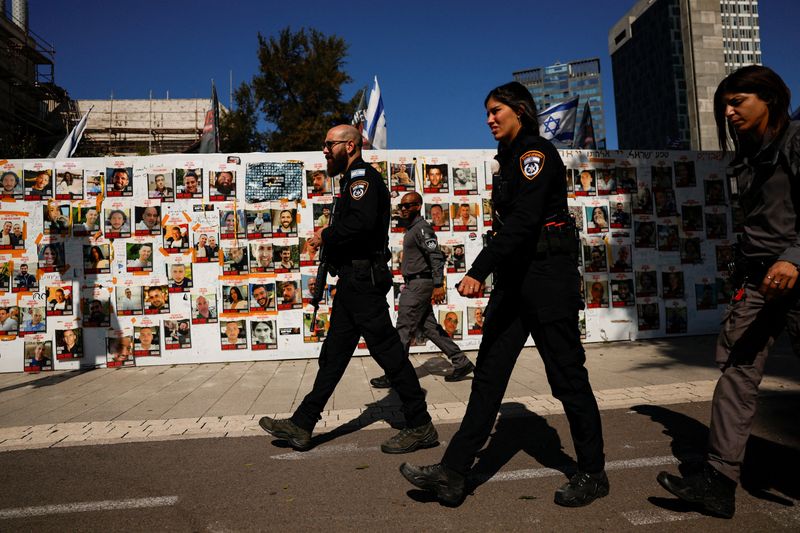 &copy; Reuters. Foto del sábado de agentes policiales de Israel cerca de una pared en Tel Aviv que muestra fotos de los rehenes en manos de Hamas 
Feb 10, 2024. REUTERS/Susana Vera
