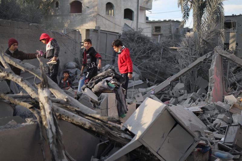 &copy; Reuters. Niños palestinos inspeccionan el lugar de un ataque israelí contra una casa, en medio del actual conflicto entre Israel y el grupo islamista palestino Hamás, en Ráfah, en el sur de la Franja de Gaza. 12 de febrero de 2024. REUTERS/Ibraheem Abu Mustafa