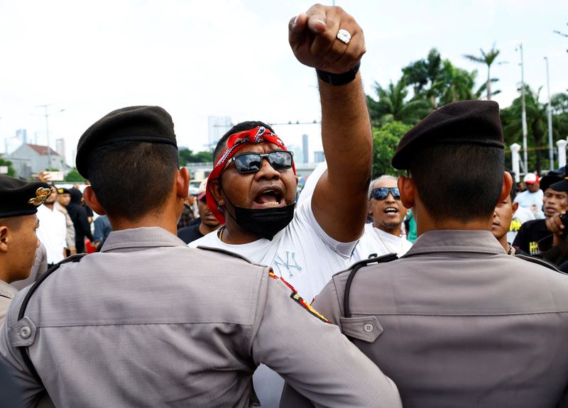 © Reuters. Police officers block pro-government protesters as they approach anti-government protesters who hold a rally demanding a fair election, outside the Indonesian parliament in Jakarta, Indonesia, February 12, 2024. REUTERS/Kim Kyung-Hoon