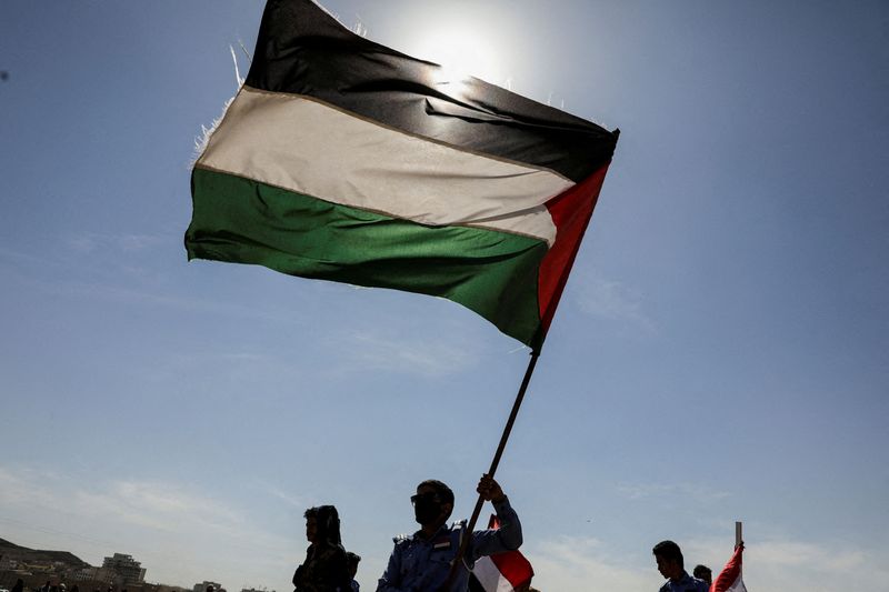 &copy; Reuters. Des partisans des Houthis tiennent un drapeau palestinien lors d'un défilé de solidarité avec les Palestiniens de la bande de Gaza et de soutien aux frappes des Houthis sur les navires de la mer Rouge et du golfe d'Aden, à Sanaa, au Yémen. /Photo pri