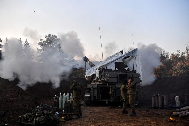 © Reuters. جنديان إسرائيليان يقفان بينما تطلق وحدة مدفعية متنقلة النيران على الجانب الإسرائيلي من الحدود الإسرائيلية اللبنانية في التاسع عشر من يناير كانون الثاني 2023 . تصوير : جيل إيلياهو  - رويترز . 