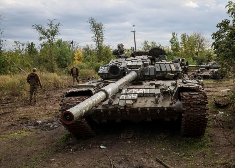 © Reuters. FILE PHOTO: Ukrainian servicemen walk near destroyed Russian tanks, as Russia's attack on Ukraine continues, in the town of Izium, recently liberated by Ukrainian Armed Forces, in Kharkiv region, Ukraine September 20, 2022. REUTERS/Gleb Garanich