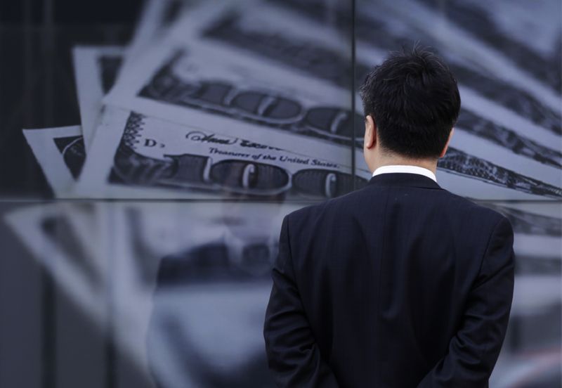 © Reuters. FILE PHOTO: A businessman looks at a screen displaying a photo of  U.S. 100 dollar bank notes in Tokyo April 8, 2013. REUTERS/Toru Hanai/File Photo