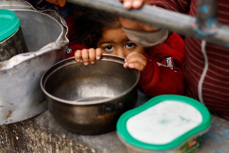 &copy; Reuters. Niños palestinos esperan a recibir alimentos en una cocina de beneficencia en medio de la escasez de suministros alimentarios, en Rafah, en el sur de la Franja de Gaza

Feb 13, 2024. REUTERS/Ibraheem Abu Mustafa