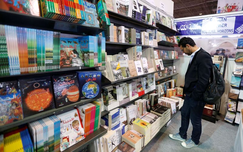 &copy; Reuters. رجل ينظر إلى مجموعة من الكتب داخل معرض تونس الدولي للكتاب في صورة من أرشيف رويترز.