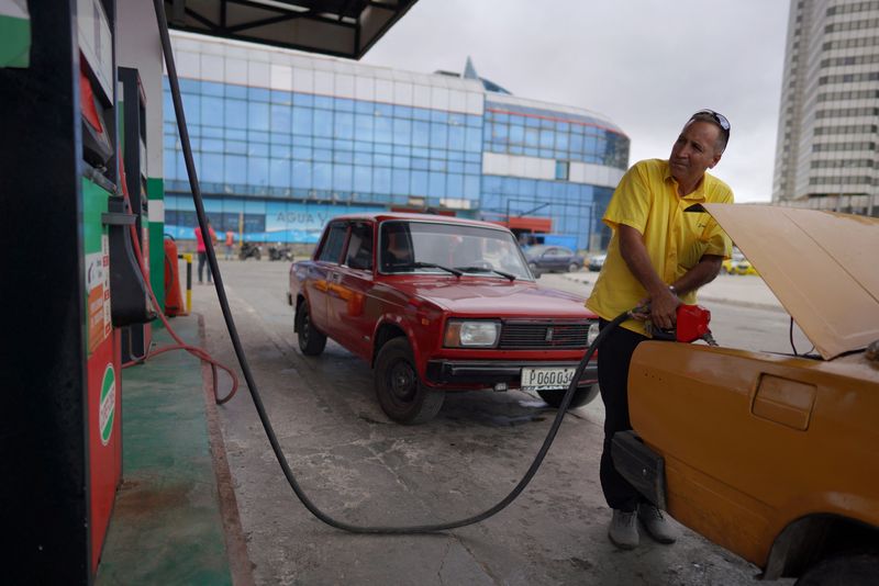 &copy; Reuters. 　２月１４日、アジア時間序盤の原油先物は反落。米週間統計で原油在庫が予想以上に増加したほか、米早期利下げ観測が後退し、相場を押し下げた。写真は給油するタクシー運転手。キュ