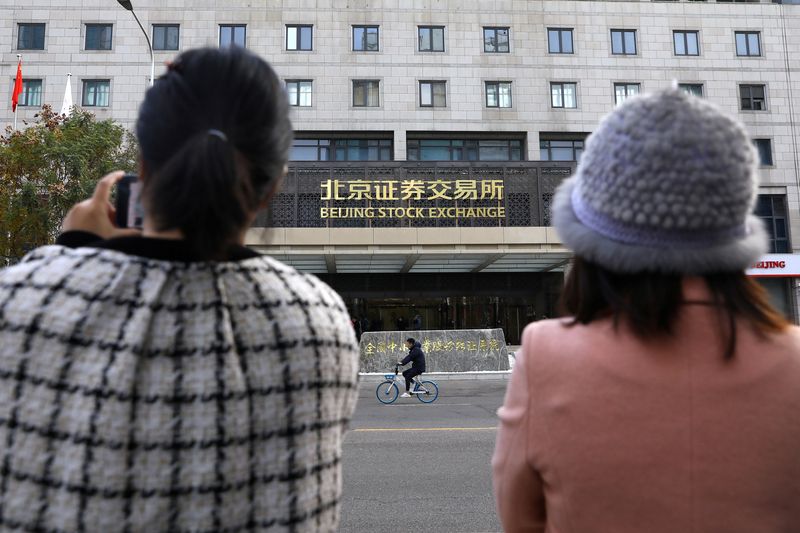 &copy; Reuters. Media reporters stand near the new Beijing Stock Exchange building at the Financial Street, in Beijing, China, November 15, 2021. REUTERS/Tingshu Wang/File Photo