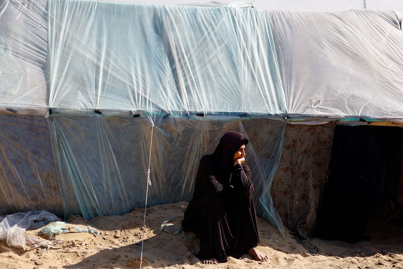 © Reuters. Una mujer palestina desplazada, que huyó de su casa debido a los ataques israelíes, se sienta junto a una tienda de campaña en Rafah, en el sur de la Franja de Gaza. 14 de febrero de 2024. REUTERS/Ibraheem Abu Mustafa  
