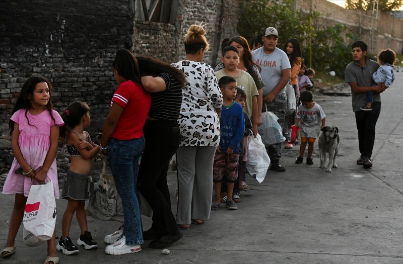 &copy; Reuters. People wait in line outside a soup kitchen to receive a ration of stew, in the working-class neighbourhood Villa Fiorito, on the outskirts of Buenos Aires, Argentina February 13, 2024. REUTERS/Martin Cossarini