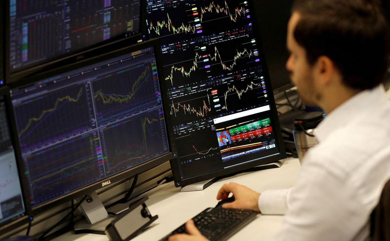 &copy; Reuters. FILE PHOTO: A financial trader works at their desk at CMC Markets in the City of London, Britain, April 11, 2019.  REUTERS/Peter Nicholls/File Photo