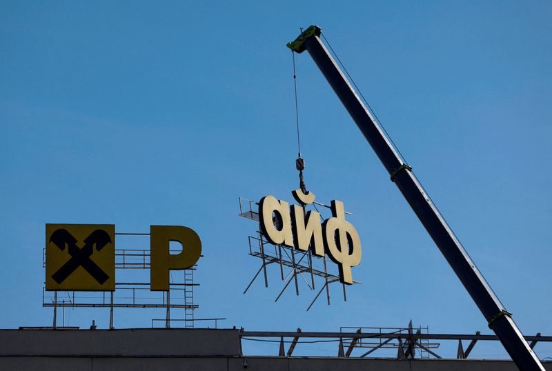 © Reuters. FILE PHOTO: Workers use a crane to dismantle a signboard advertising Raiffeisen Bank from a building in Moscow, Russia April 14, 2023. REUTERS/Maxim Shemetov/File Photo