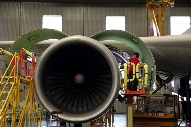 © Reuters. An IAG Iberia's worker inspects an engine after transforming an Airbus 330 passenger aircraft into a cargo one to face the drop in flights due to the coronavirus pandemic at Iberia's maintenance hangar in Madrid, Spain, December 4, 2020. Picture taken December 4, 2020. REUTERS/Sergio Perez/File Photo