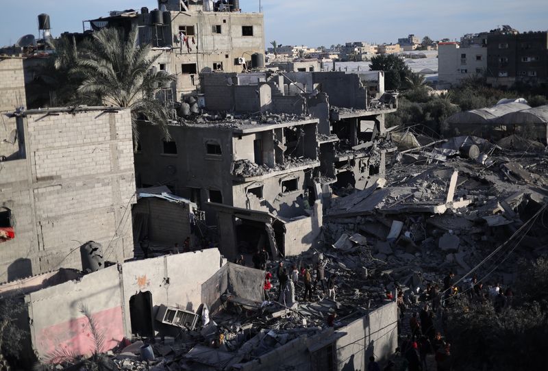 © Reuters. فلسطينيون يتفقدون موقع غارة إسرائيلية على منزل في رفح بجنوب قطاع غزة يوم 12 فبراير شباط 2024. تصوير: إبراهيم أبو مصطفى - رويترز.
