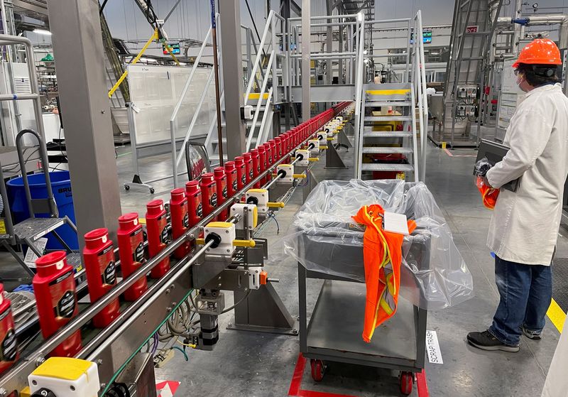 &copy; Reuters. FILE PHOTO: A person works with robots at Procter & Gamble's factory in Tabler Station, West Virginia, U.S., May 28, 2021. REUTERS/Timothy Aeppel/File Photo