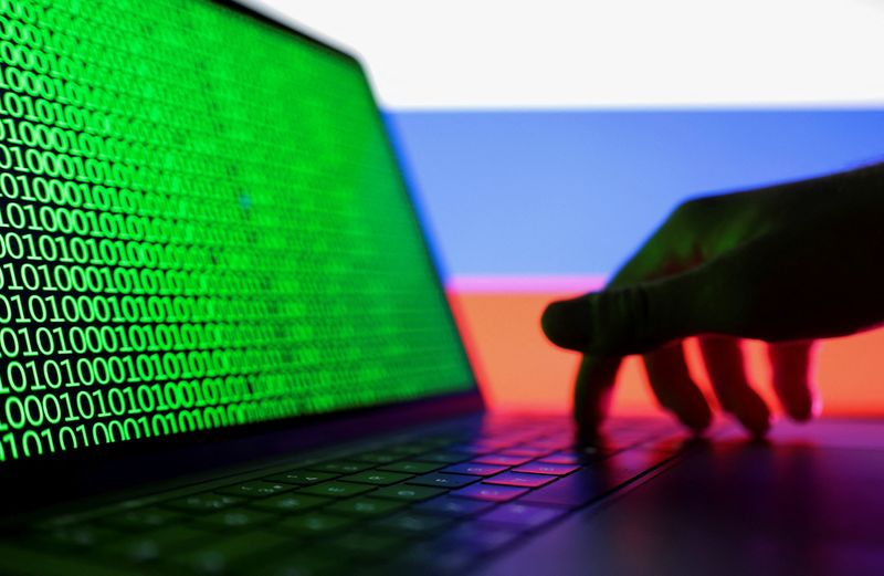 © Reuters. A hand is seen on a laptop with binary code displayed on the screen in front of Russian flag in this picture illustration taken August 19, 2022. REUTERS/Dado Ruvic/Illustration