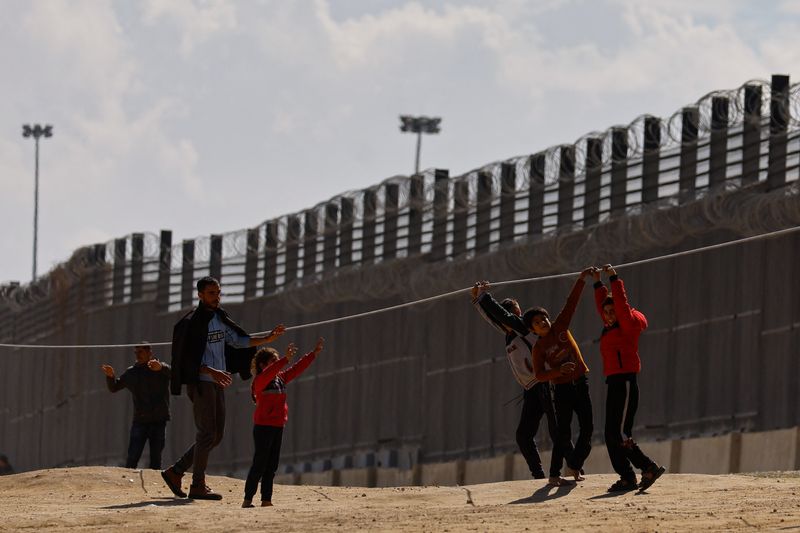 &copy; Reuters. Niños palestinos desplazados, que huyeron de sus casas debido a los ataques israelíes, juegan mientras se refugian en la frontera con Egipto, en medio del conflicto en curso entre Israel y el grupo islamista palestino Hamás, en Ráfah, en el sur de la 