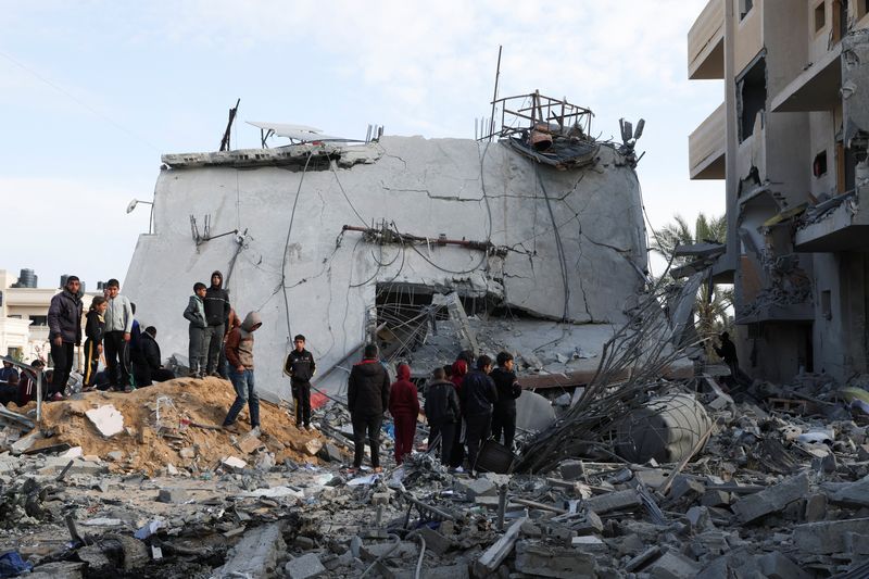 &copy; Reuters. Palestinians gather near a house hit by an Israeli strike, in Rafah in the southern Gaza Strip February 16, 2024. REUTERS/Ibraheem Abu Mustafa