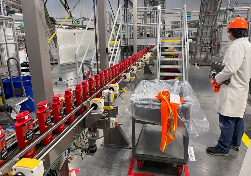 &copy; Reuters. Una persona lavora con i robot nello stabilimento di Procter & Gamble a Tabler Station, West Virginia, Stati Uniti, 28 maggio 2021. Foto REUTERS/Timothy Aeppel/File Photo