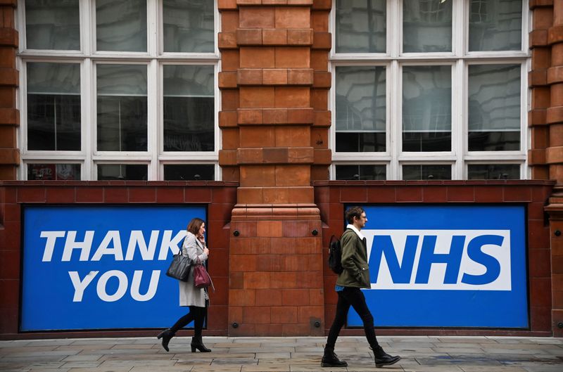 &copy; Reuters. FILE PHOTO: People walk past a thank you message for the National Health Service (NHS) near the venue where the annual Conservative Party Conference is taking place, in Manchester, Britain, October 5, 2021. REUTERS/Toby Melville/File Photo