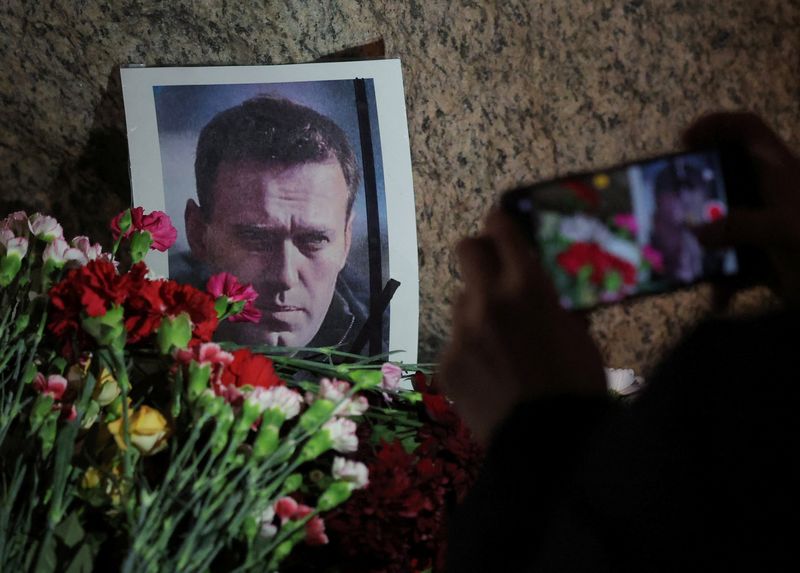 &copy; Reuters. Flores colocadas ao lado de uma foto do líder da oposição russa Alexei Navalny no monumento às vítimas da repressão política, em São Petersburgo, Rússia, após a morte de Navalny 
16/02/2024
REUTERS/Stringer