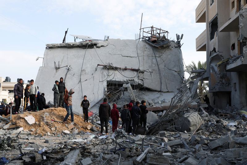 &copy; Reuters. Palestinos se reúnen cerca de una casa alcanzada por un ataque israelí, en Rafah, en el sur de la Franja de Gaza, el 16 de febrero de 2024. REUTERS/Ibraheem Abu Mustafa