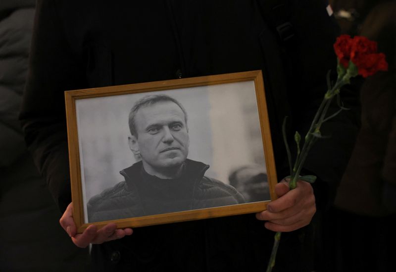 &copy; Reuters. A person holds flowers and a portrait of Russian opposition leader Alexei Navalny at the monument to the victims of political repressions following Navalny's death, in Saint Petersburg, Russia February 16, 2024. REUTERS/Stringer