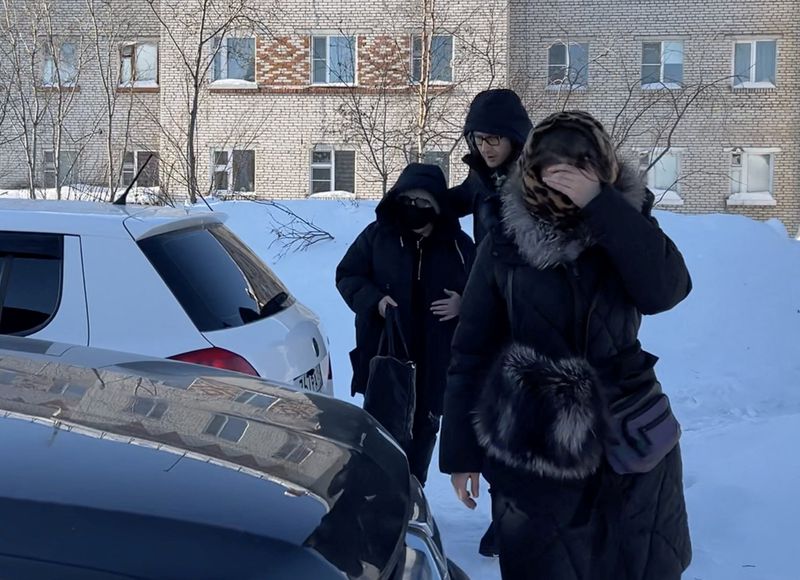 &copy; Reuters. A woman (L) wearing a protective mask and sunglasses, believed to be Lyudmila Navalnaya, the mother of Russian opposition leader Alexei Navalny, is accompanied into a car as she leaves the IK-3 penal colony, where her son served his jail term and where he
