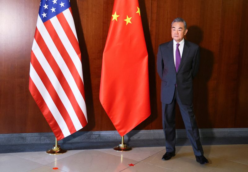 &copy; Reuters. وزير الخارجية الصيني وانغ يي يقف إلى جانب العلمين الصيني والأمريكي خلال مشاركته في مؤتمر ميونيخ للأمن بألمانيا يوم الجمعة . تصوير : فولفجانج
