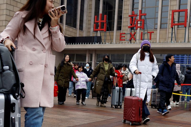 &copy; Reuters. Des voyageurs marchent avec leurs bagages à l'extérieur de la gare de Pékin pendant la Fête du Printemps, après les huit jours de vacances du Nouvel An lunaire, à Pékin, en Chine. /Photo prise le 18 février 2024/REUTERS/Florence Lo