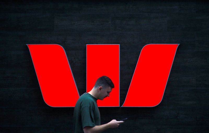 &copy; Reuters. A pedestrian looks at his phone as he walks past a logo for Australia's Westpac Banking Corp located outside a branch in central Sydney, Australia, November 5, 2018. REUTERS/David Gray/File Photo