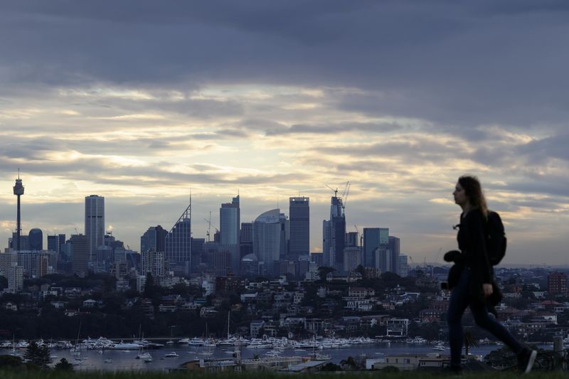 © Reuters. A woman walks on a hill overlooking the city centre skyline amidst the easing of restrictions implemented to curb the spread of the coronavirus disease (COVID-19) in Sydney, Australia June 29, 2020.  REUTERS/Loren Elliott