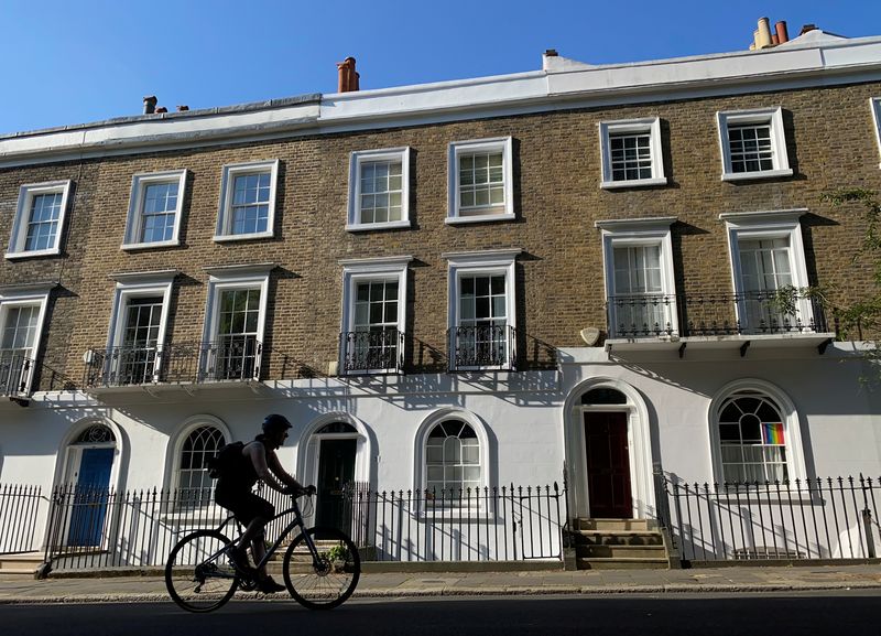&copy; Reuters. A person on a bicycle rides past houses on a street early in the morning in Islington, London, Britain, June 22, 2020. REUTERS/Simon Newman/File Photo