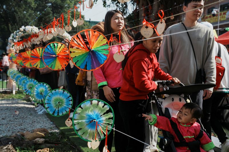 &copy; Reuters. People walk past pinwheels at a market on the first day of the Lunar New Year of the Dragon, in Hong Kong, China February 10, 2024. REUTERS/Lam Yik/file photo
