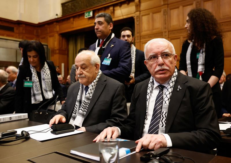 © Reuters. Palestinian Foreign Minister Riyad al-Maliki and Palestinian U.N. envoy Riyad Mansour attend a public hearing held by The International Court of Justice (ICJ) to allow parties to give their views on the legal consequences of Israel's occupation of the Palestinian territories before eventually issuing a non-binding legal opinion in The Hague, Netherlands, February 19, 2024. REUTERS/Piroschka van de Wouw