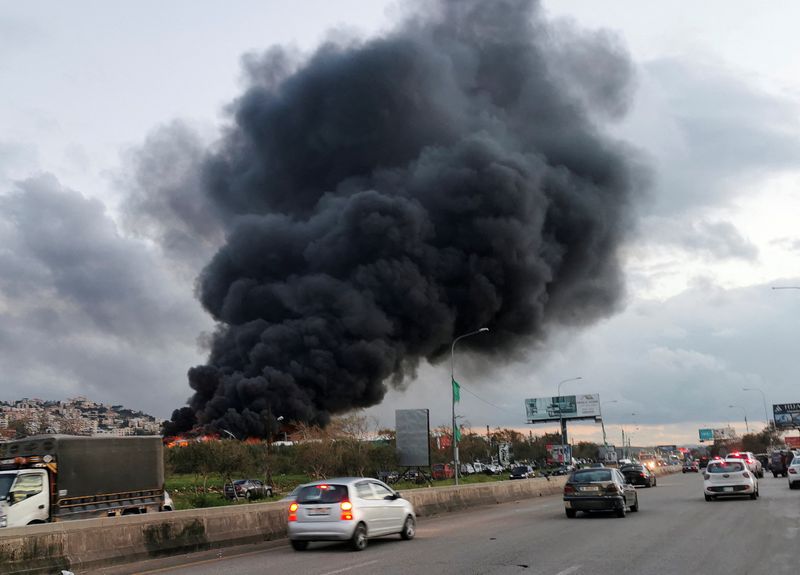 &copy; Reuters. Des véhicules roulent alors que de la fumée s'élève d'un site touché par une frappe aérienne près de la ville de Ghaziyeh, au Liban. /Photo prise le 19 février 2024/REUTERS/Hassan Hankir